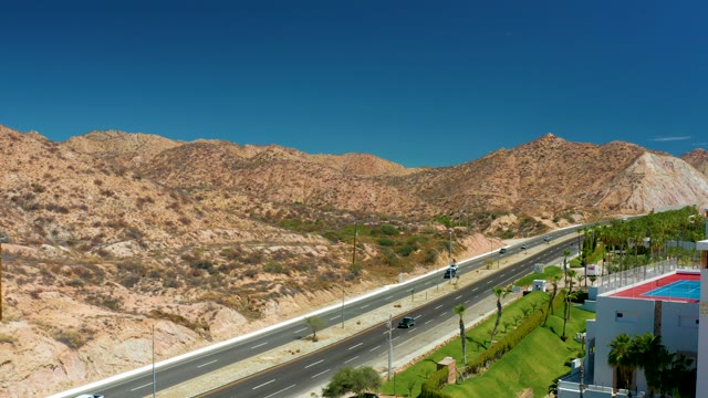 MARQUIS LOS CABOS MEXICO-2021: Highway Traffic Through Mountainous Desert Landscape