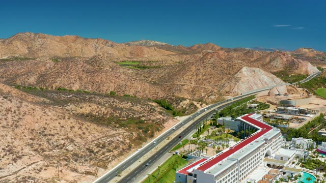 MARQUIS LOS CABOS MEXICO-2021: Desert Highway with Moving Vehicles and Mountain Backdrop