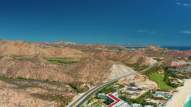 MARQUIS LOS CABOS MEXICO-2021: Coastal Road and Sandy Beach by Arid Mountains
