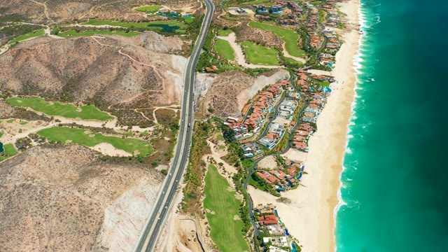 MARQUIS LOS CABOS MEXICO-2021: Coastal Highway with Moving Vehicles and Beachfront Development