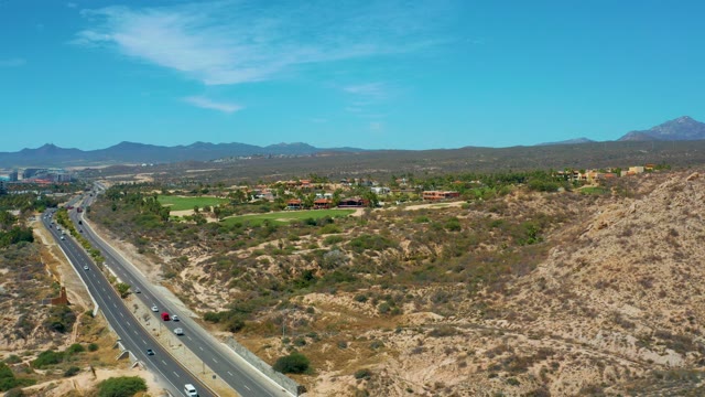 MARQUIS LOS CABOS MEXICO-2021: Vehicles Moving Along a Hilly Highway in Dry Terrain