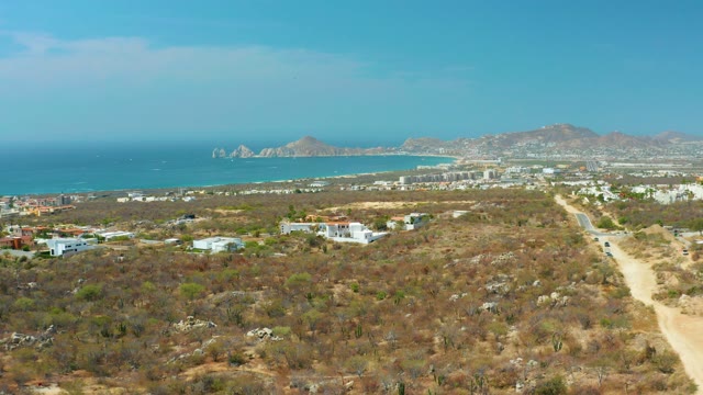 CABO SAN LUCAS BCS MEXICO-2021: Coastal Desert Landscape with Road and Distant Buildings