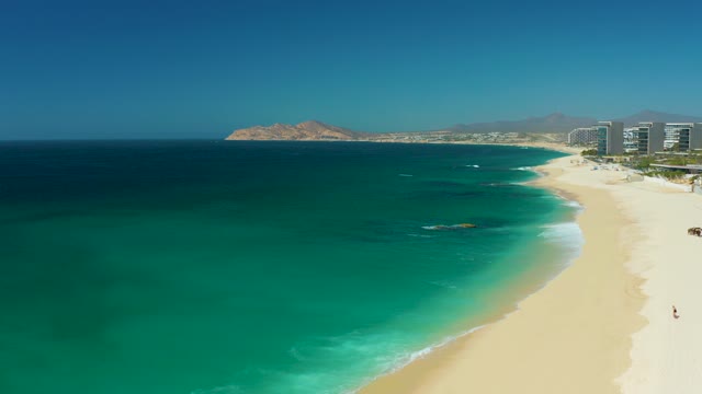 DREAMS LOS CABOS BCS MEXICO-2021: People Moving Along a Sandy Beach by the Ocean