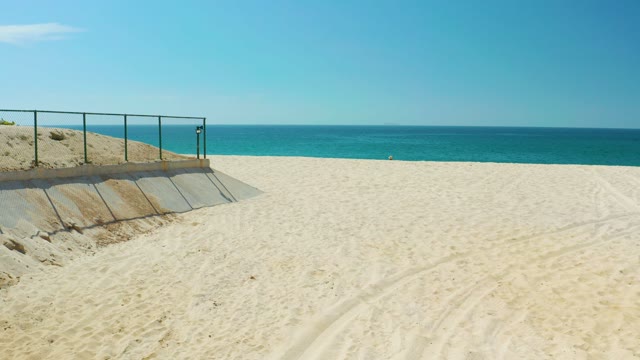 DREAMS LOS CABOS BCS MEXICO-2021: Receding Ocean Water on Sandy Beach with Railing