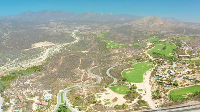 DREAMS LOS CABOS BCS MEXICO-2021: Winding Road with Vehicles Moving Through Hilly Landscape