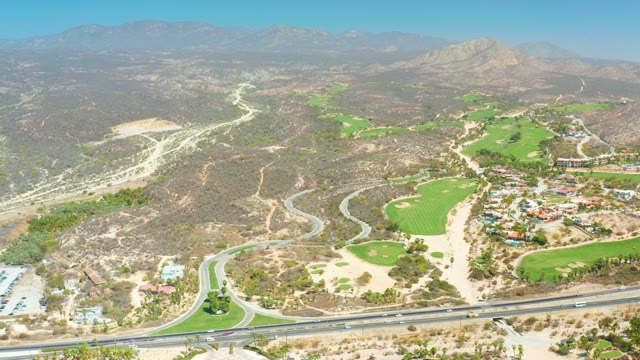 DREAMS LOS CABOS BCS MEXICO-2021: Highway Traffic and Golf Course in Hilly Landscape