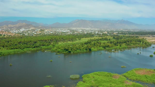 SAN JOSE DEL CABO BCS MEXICO-2021: River with Small Green Islets and Distant Mountains