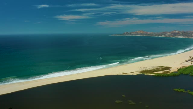 SAN JOSE DEL CABO BCS MEXICO-2021: Sandy Beach and Ocean with Drifting Clouds and Gentle Waves