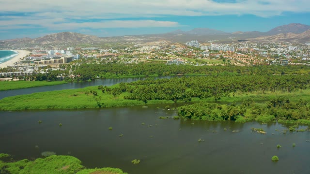 SAN JOSE DEL CABO BCS MEXICO-2021: Coastal River with Greenery and Urban Background