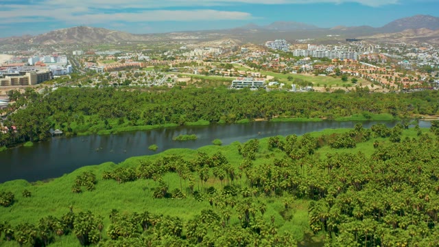 SAN JOSE DEL CABO BCS MEXICO-2021: River Winding Through Lush Green Area and Cityscape
