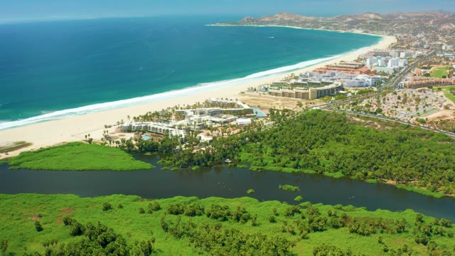 SAN JOSE DEL CABO BCS MEXICO-2021: Coastal Scene with Clouds Drifting Over Beach and Greenery