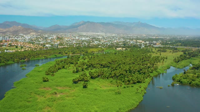 SAN JOSE DEL CABO BCS MEXICO-2021: Small Boat Navigating River Near Lush Island