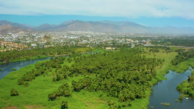 SAN JOSE DEL CABO BCS MEXICO-2021: River Flowing Through Lush Green Fields and Distant Town