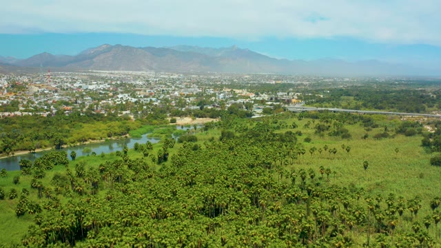 SAN JOSE DEL CABO BCS MEXICO-2021: River Flowing Through Lush Fields and Distant Town