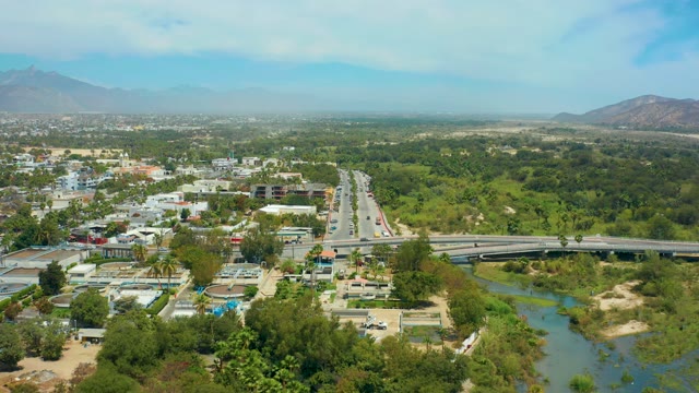 SAN JOSE DEL CABO BCS MEXICO-2021: Urban Highway Traffic Flowing Near River and Greenery