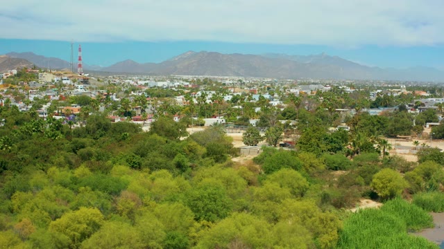 SAN JOSE DEL CABO BCS MEXICO-2021: Aerial Pan Over Suburban Greenery and Distant Mountains