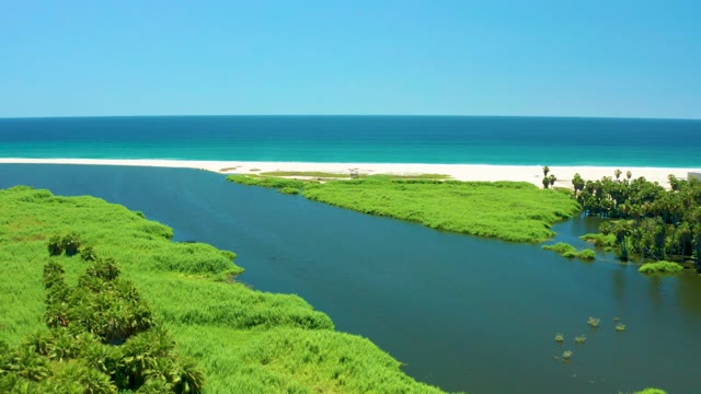 SAN JOSE DEL CABO ESTUARY BCS MEXICO-2021: River Flowing Into Ocean with Sandy Beach and Green Banks