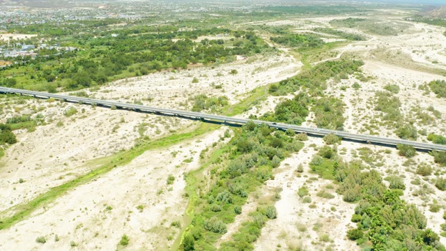 SAN JOSE DEL CABO ESTUARY BCS MEXICO-2021: Train Crossing a Bridge over Arid Landscape