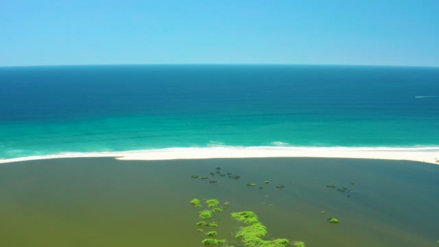 SAN JOSE DEL CABO ESTUARY BCS MEXICO-2021: Waves Rolling Onto Sandy Beach with Lagoon Vegetation
