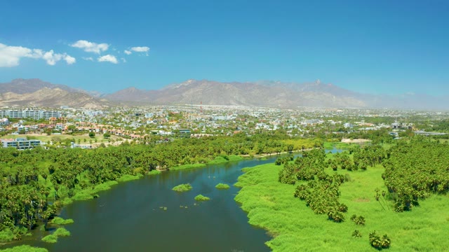 SAN JOSE DEL CABO ESTUARY BCS MEXICO-2021: River Flowing Through Lush Green Fields and Distant City