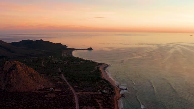 CABO PULMO BCS MEXICO-2021: Coastal Sunset with Gentle Ocean Waves and Mountainous Shoreline