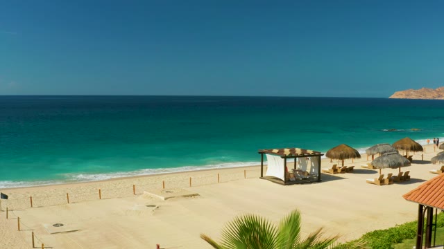 HILTON LOS CABOS MEXICO-2021: Sandy Beach with Thatched Umbrellas and Swinging Palm Fronds