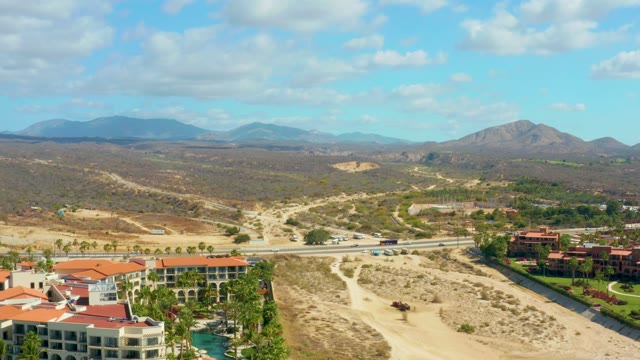 HILTON LOS CABOS MEXICO-2021: Vehicles Moving on Desert Highway with Residential Buildings