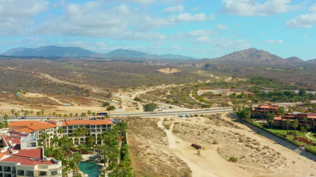 HILTON LOS CABOS MEXICO-2021: Moving Cars on Road Near Desert Buildings