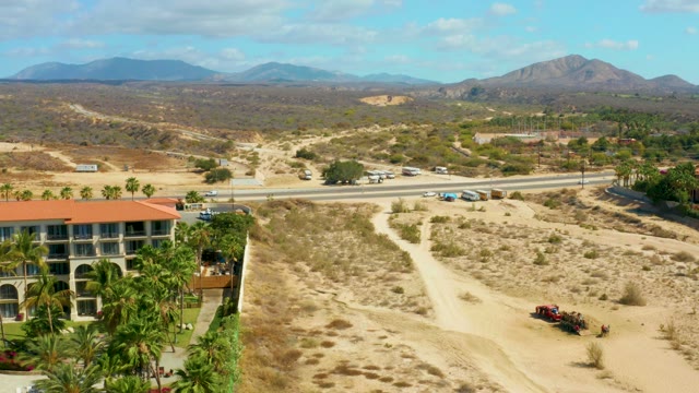 HILTON LOS CABOS MEXICO-2021: Vehicle Moving on a Desert Path Near a Building