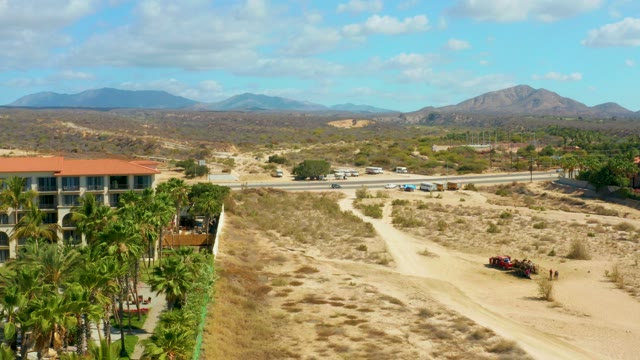 HILTON LOS CABOS MEXICO-2021: Desert Road with Building and Moving Traffic