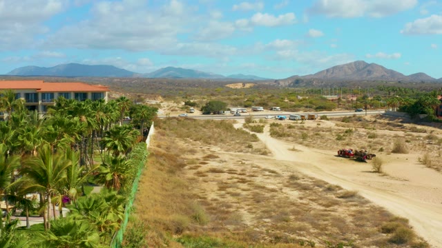 HILTON LOS CABOS MEXICO-2021: Dirt Path with Moving Cart and Swaying Palm Trees
