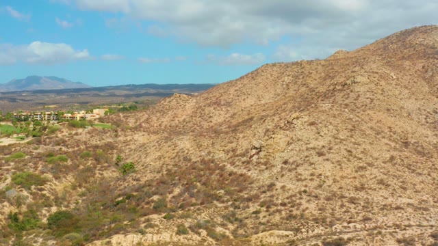 HILTON LOS CABOS MEXICO-2021: Arid Hillside with Sparse Vegetation and Distant Buildings
