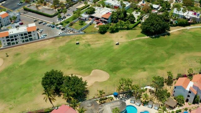 SAN JOSE DEL CABO BCS MEXICO-2021: Golf Carts Moving on a Course with Buildings