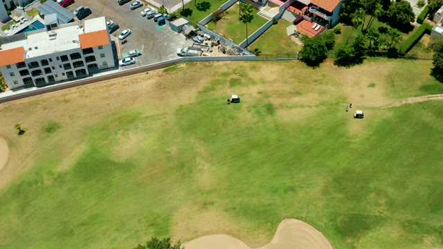 SAN JOSE DEL CABO BCS MEXICO-2021: Golf Carts Moving Across a Grassy Course