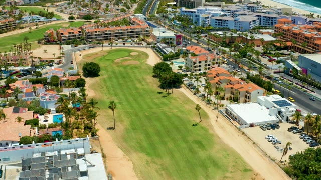 SAN JOSE DEL CABO BCS MEXICO-2021: Golf Course with Urban Buildings and Moving Traffic
