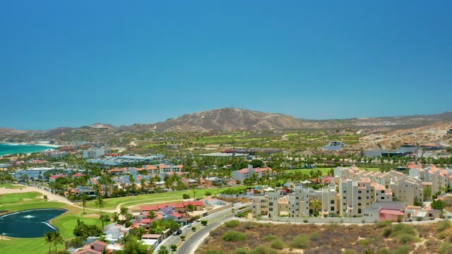 SAN JOSE DEL CABO BCS MEXICO-2021: Coastal Golf Course with Road Traffic and Mountain Backdrop