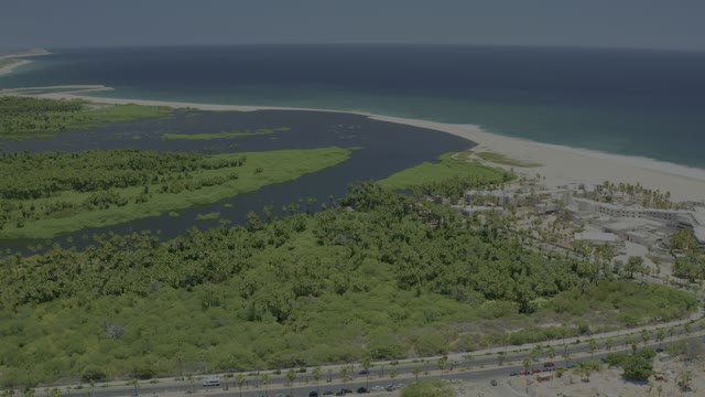 SAN JOSE DEL CABO BCS MEXICO-2021: Coastal Highway Traffic Near Sandy Beach and Waterway