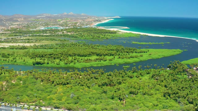 SAN JOSE DEL CABO BCS MEXICO-2021: Coastal River Flows Through Lush Greenery Near Road