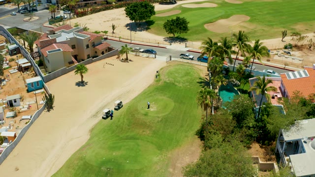 SAN JOSE DEL CABO BCS MEXICO-2021: Golfer on a Golf Course with Surrounding Buildings