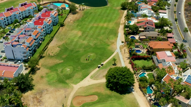SAN JOSE DEL CABO BCS MEXICO-2021: Golfers and Car Moving on Residential Golf Course