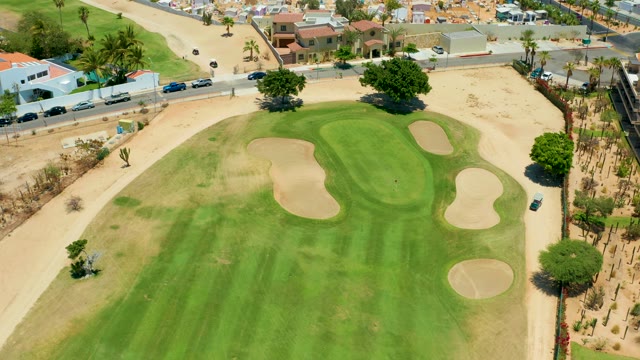 SAN JOSE DEL CABO BCS MEXICO-2021: Golf Course Green with Sand Traps and Moving Vehicles