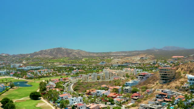 SAN JOSE DEL CABO BCS MEXICO-2021: Vehicle Driving on Road Near Golf Course and Mountains