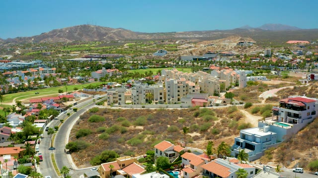 SAN JOSE DEL CABO BCS MEXICO-2021: Vehicles Traveling on Winding Residential Road with Hillside View