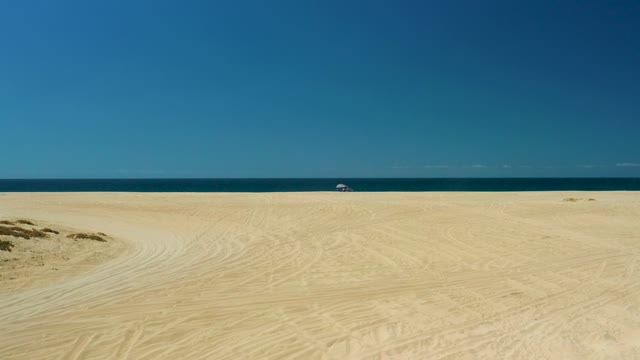 LA LAGUNA BEACH LOS CABOS MEXICO-2021: Person Relaxing Under Beach Umbrella on Sandy Shore