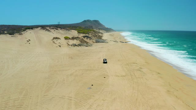 LA LAGUNA BEACH LOS CABOS MEXICO-2021: Car Driving on Sandy Beach Toward Camera