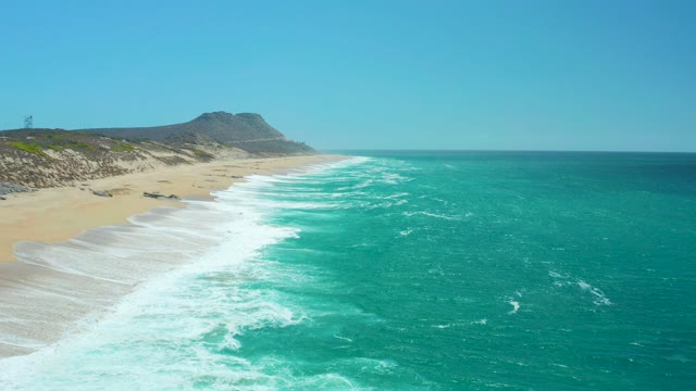 LA LAGUNA BEACH LOS CABOS MEXICO-2021: Ocean Waves Rolling Onto Sandy Coastline