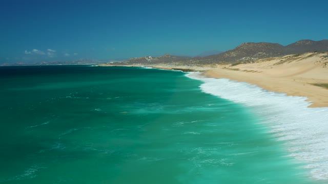 LA LAGUNA BEACH LOS CABOS MEXICO-2021: Waves Rolling Onto Sandy Beach