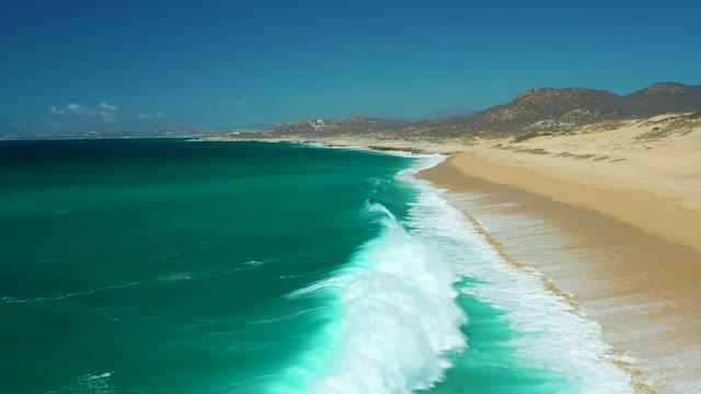 LA LAGUNA BEACH LOS CABOS MEXICO-2021: Turquoise Ocean Waves Crashing on Sandy Shore