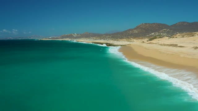LA LAGUNA BEACH LOS CABOS MEXICO-2021: Gentle Ocean Waves Rolling Onto Sandy Shore