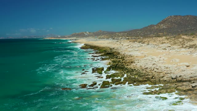 LA LAGUNA BEACH LOS CABOS MEXICO-2021: Waves Crashing on Rocky Coastal Shore